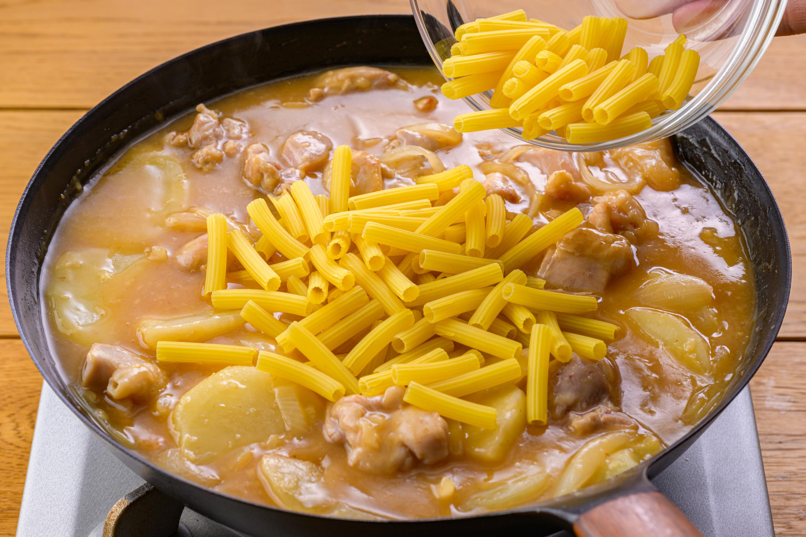 Adding macaroni to the pan