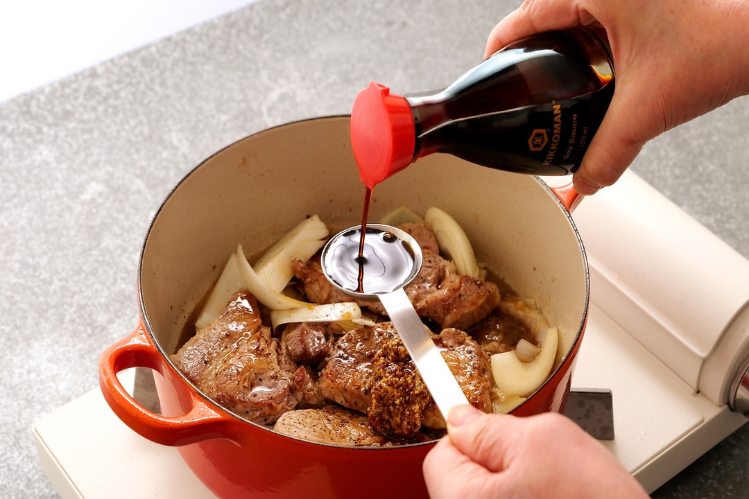 Adding Kikkoman Soy Sauce to a pot