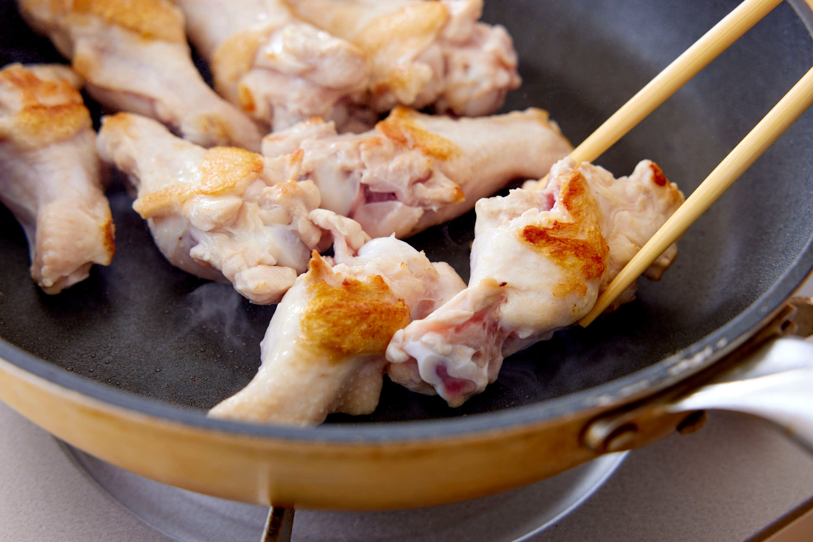 Cooking chicken drumettes in a fry pan