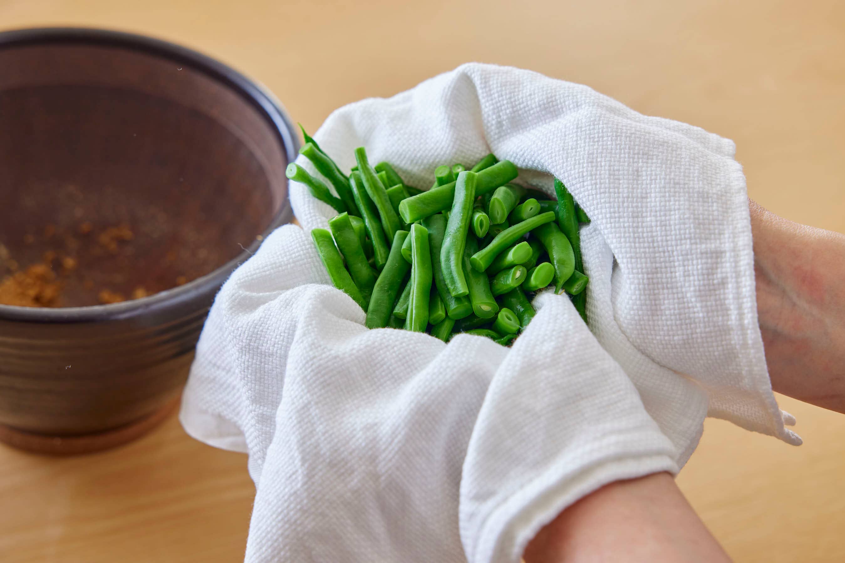 Patting the green beans dry thoroughly with a cloth