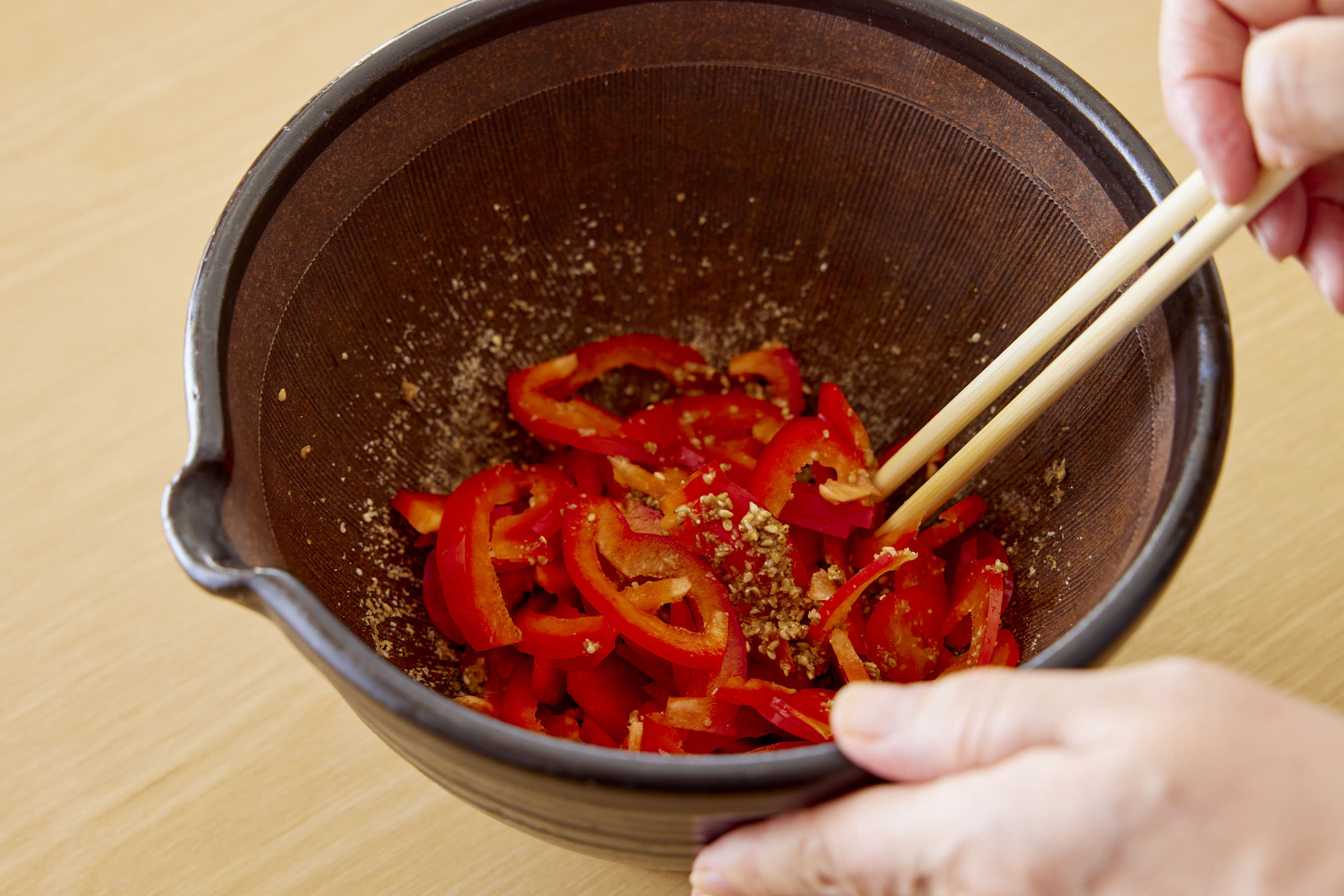 Mixing bell peppers with the sesame dressing