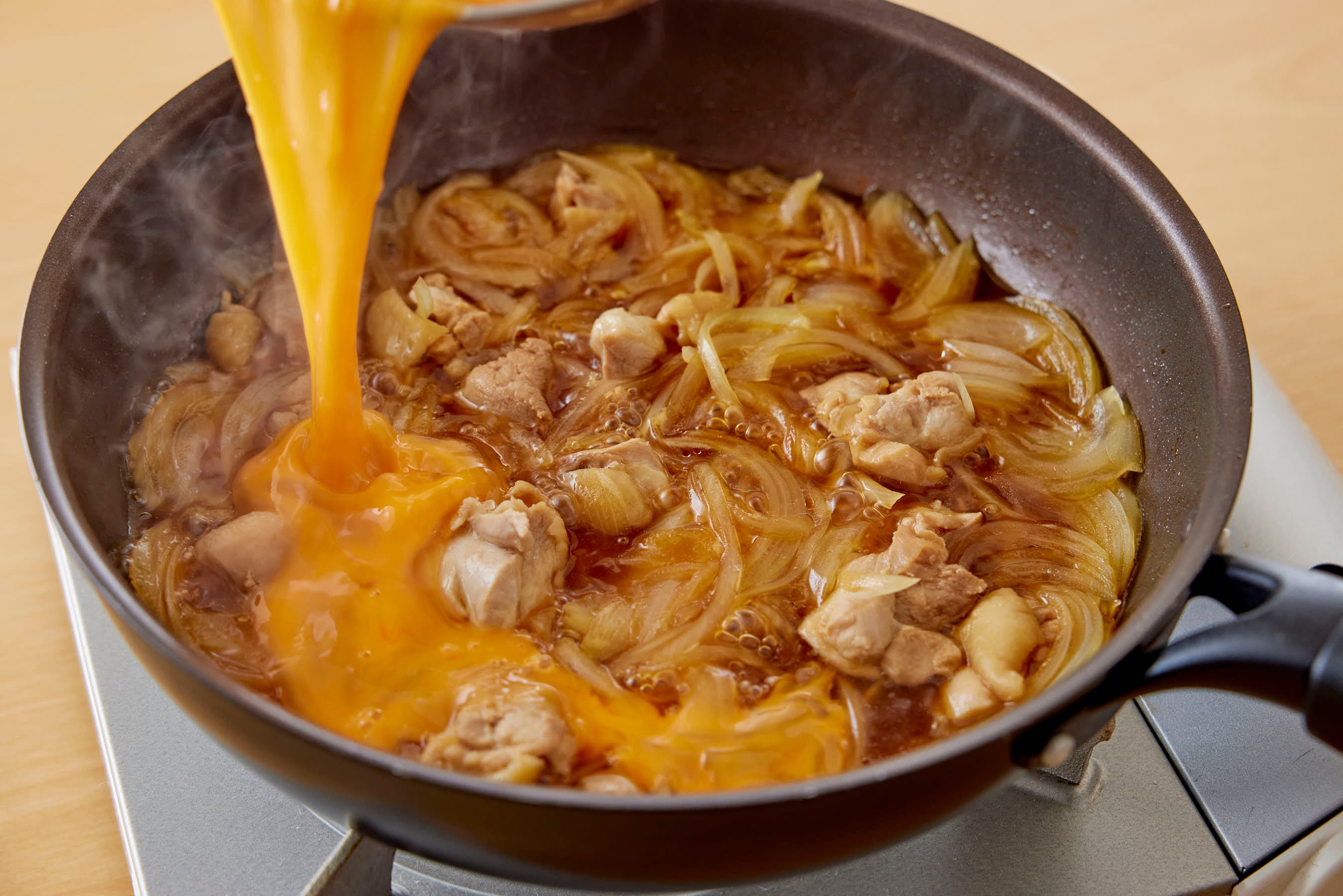 Egg Added To Chicken And Onion In Pan