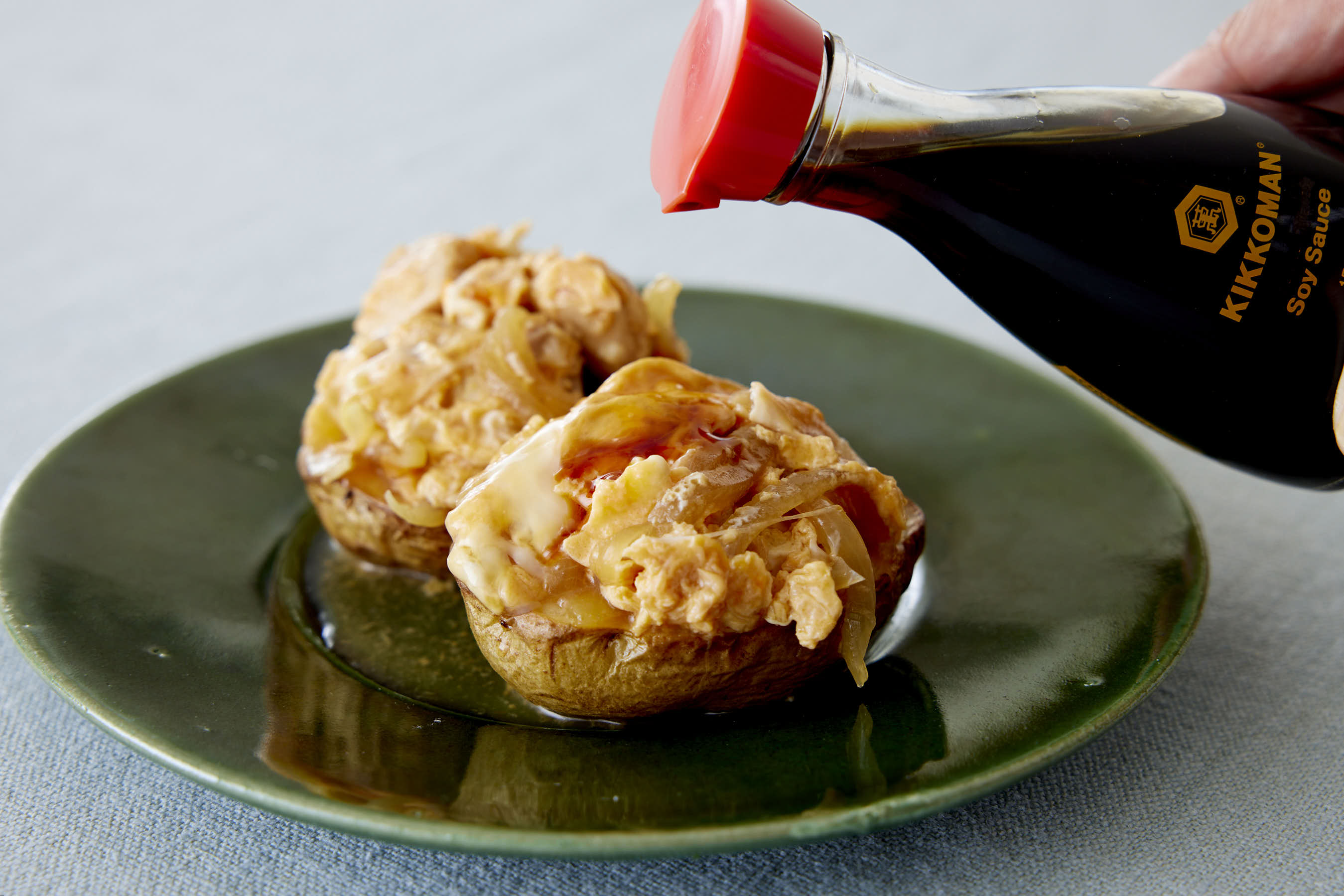 Drizzling Kikkoman Soy Sauce over baked potatoes