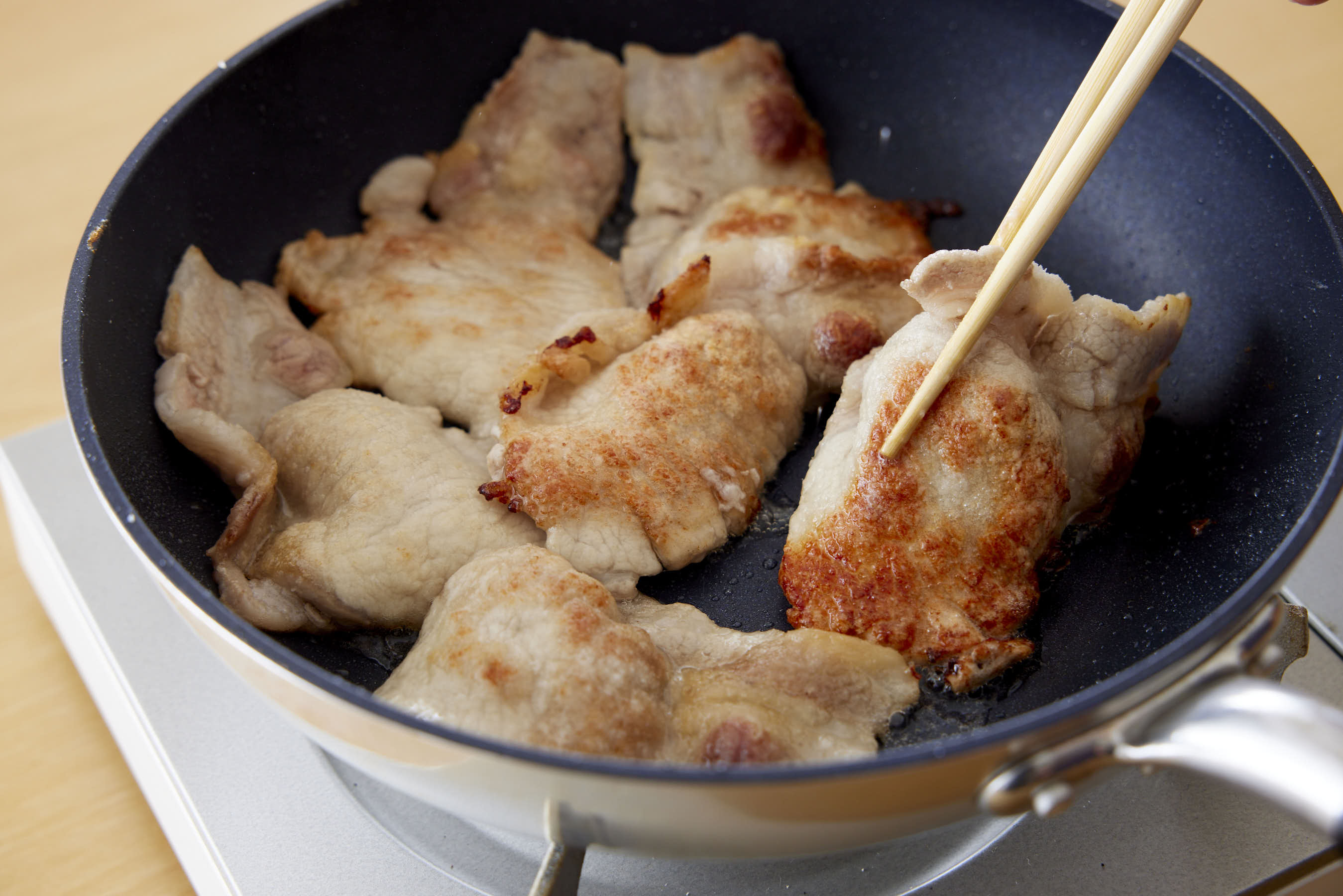 Flipping pork in a fry pan