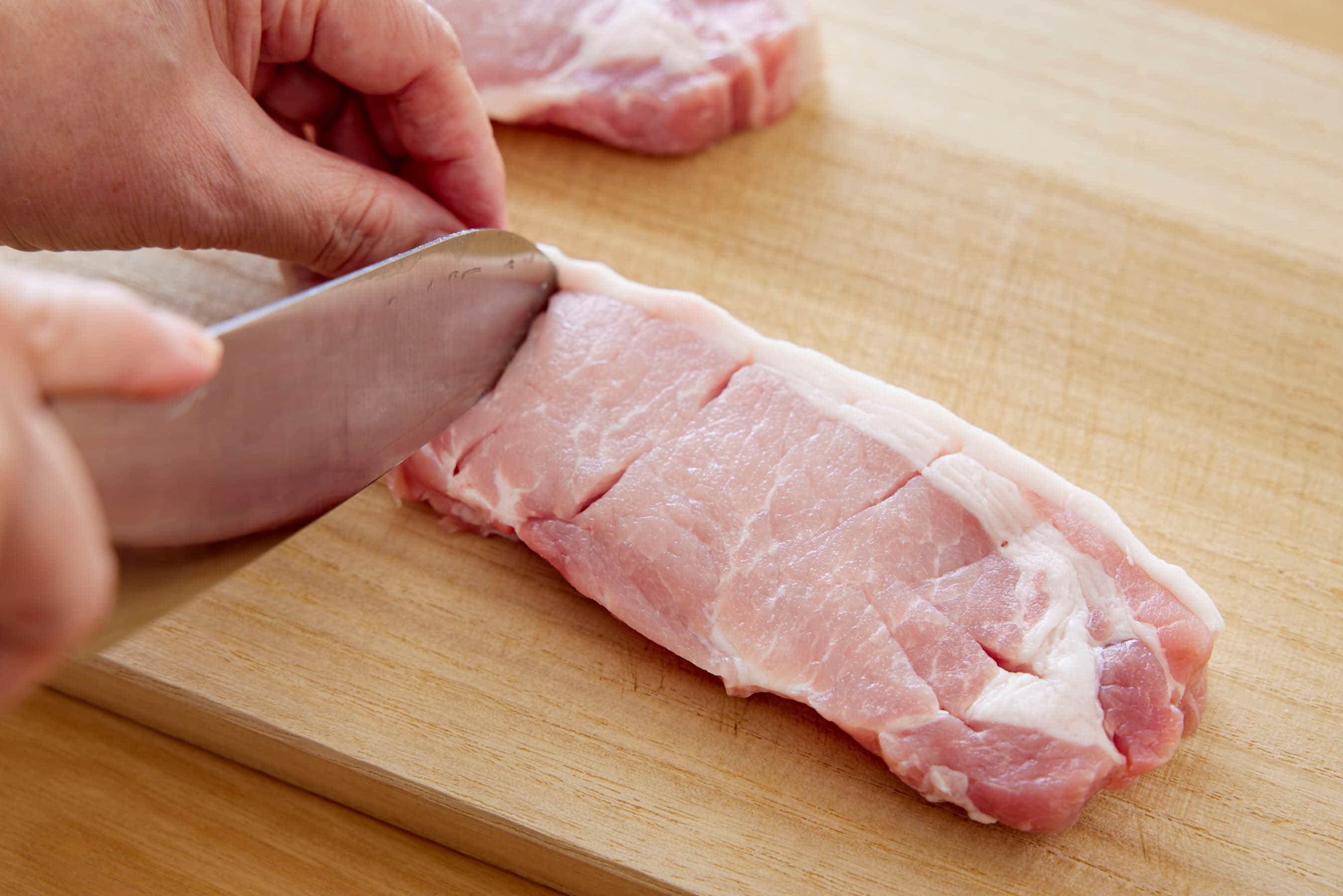 Making small cuts in the pork