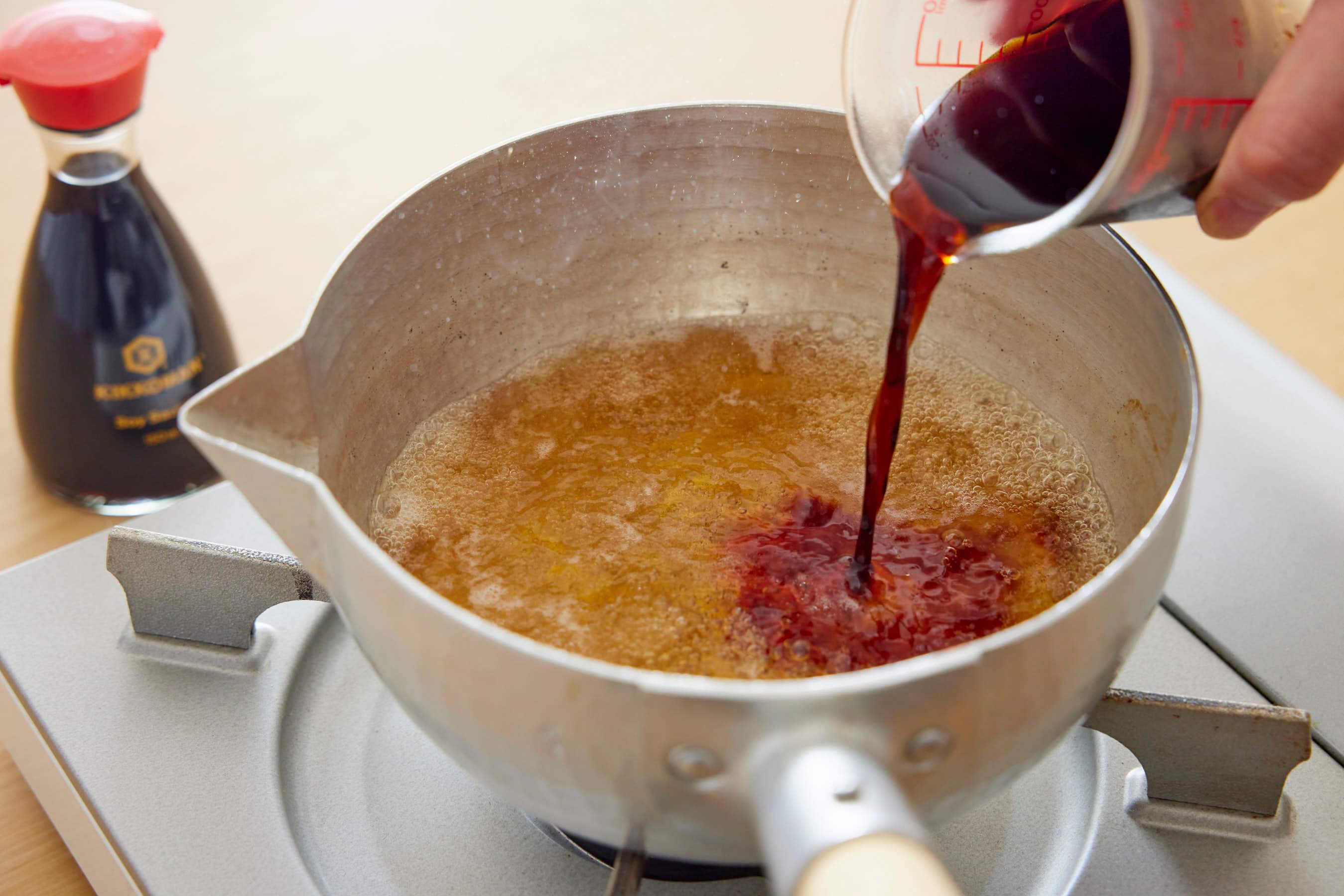 Adding Kikkoman Soy Sauce to the pot