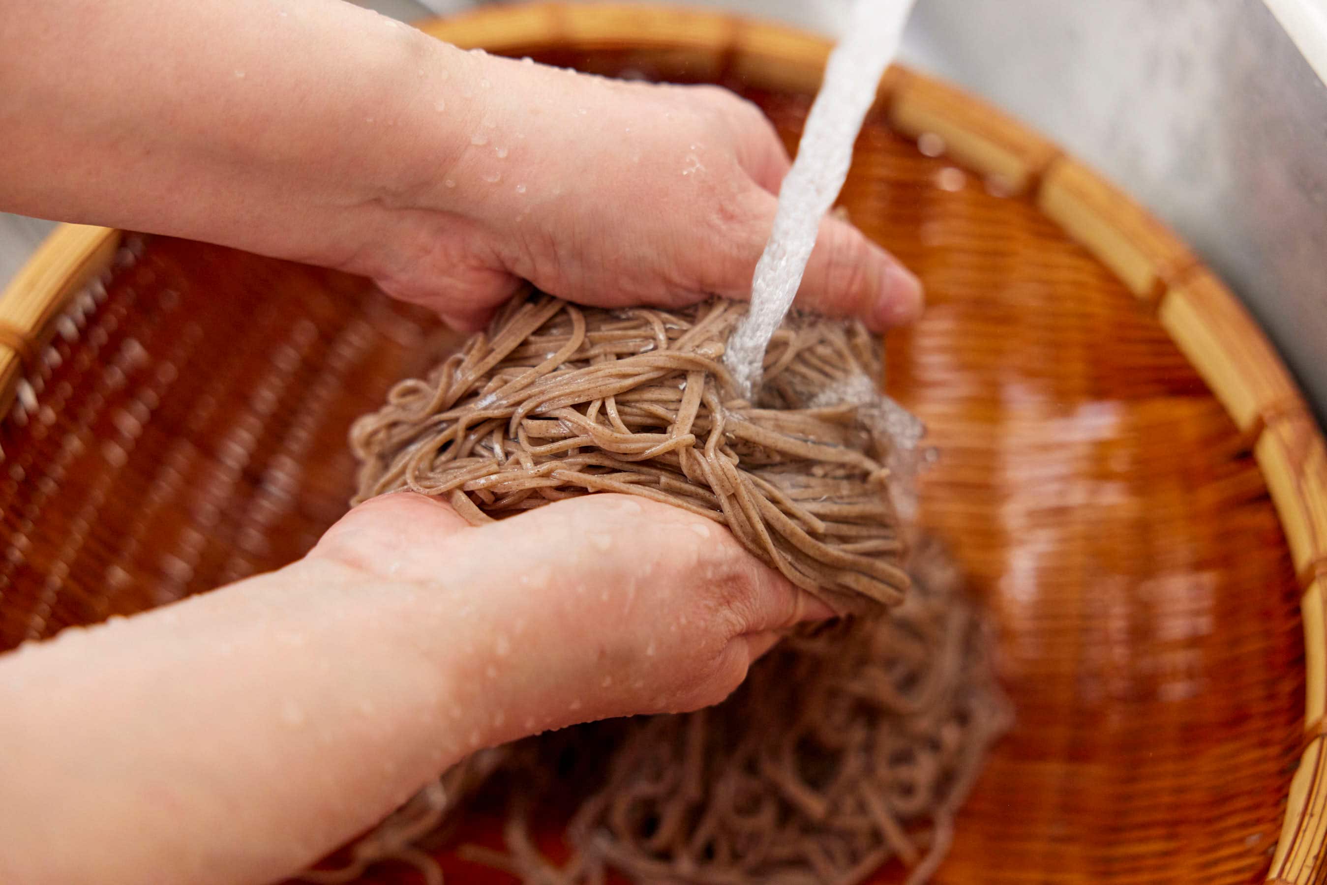 Rinsing soba noodles under running water