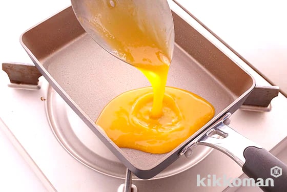 4. Pour a ladle of the egg mixture into the pan.