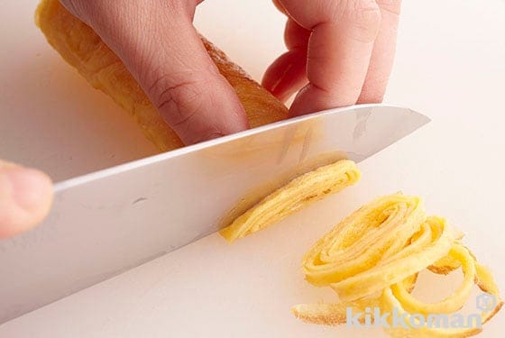 7. Stack the usuyaki tamago and cut into thin strips. If you roll these up first, it will be easier to thinly slice up.