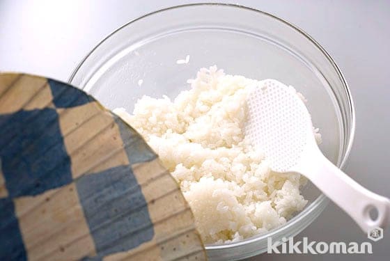 5．Mix with a rice paddle while fanning with a fan. Mixing the rice as if breaking apart to prevent from sticking. It's ready when the rice looks glossy and the heat is removed.