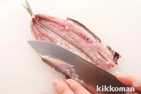 Lay the knife flat and slice away the stomach bones. This completes the butterflying process.