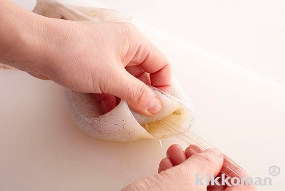 Pull out the quill or cuttlebone (thin, clear sliver of cartilage) inside of the body. Remove any remaining innards inside of the body by scraping with a knife, then rinse with water and dry off.