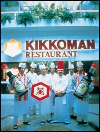 1987年にオープンした西ドイツ「大都会フランクフルト店」。オープニング・セレモニーで従業員達がディスプレイ用の大型キッコーマンしょうゆ壜を抱えている